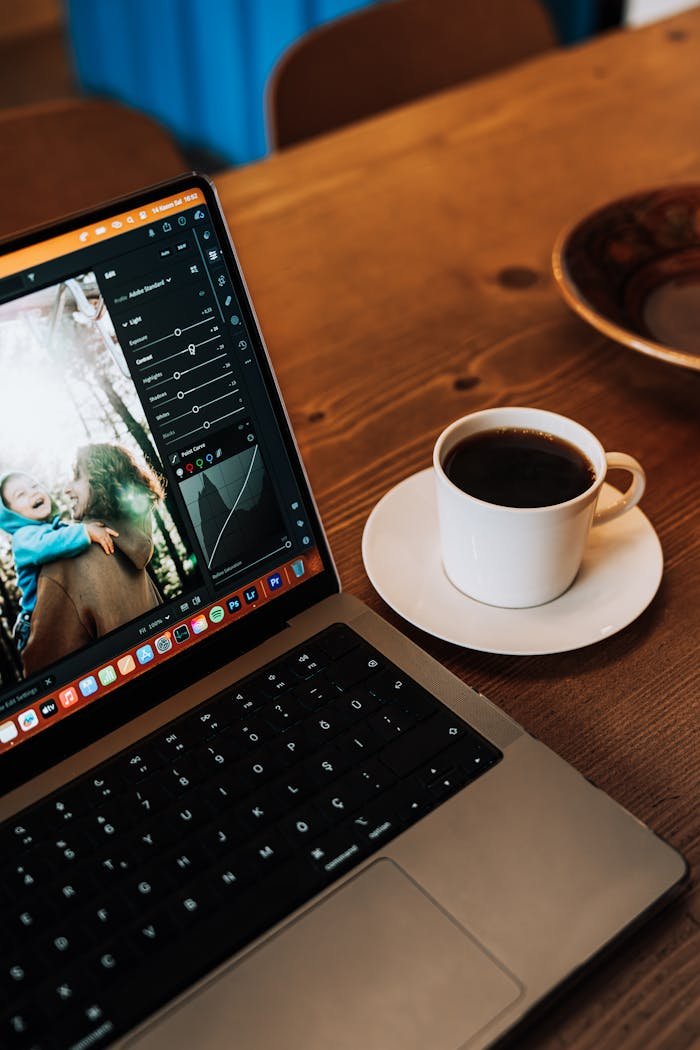 Warm wooden table with a laptop and coffee cup, perfect for a relaxing workspace.